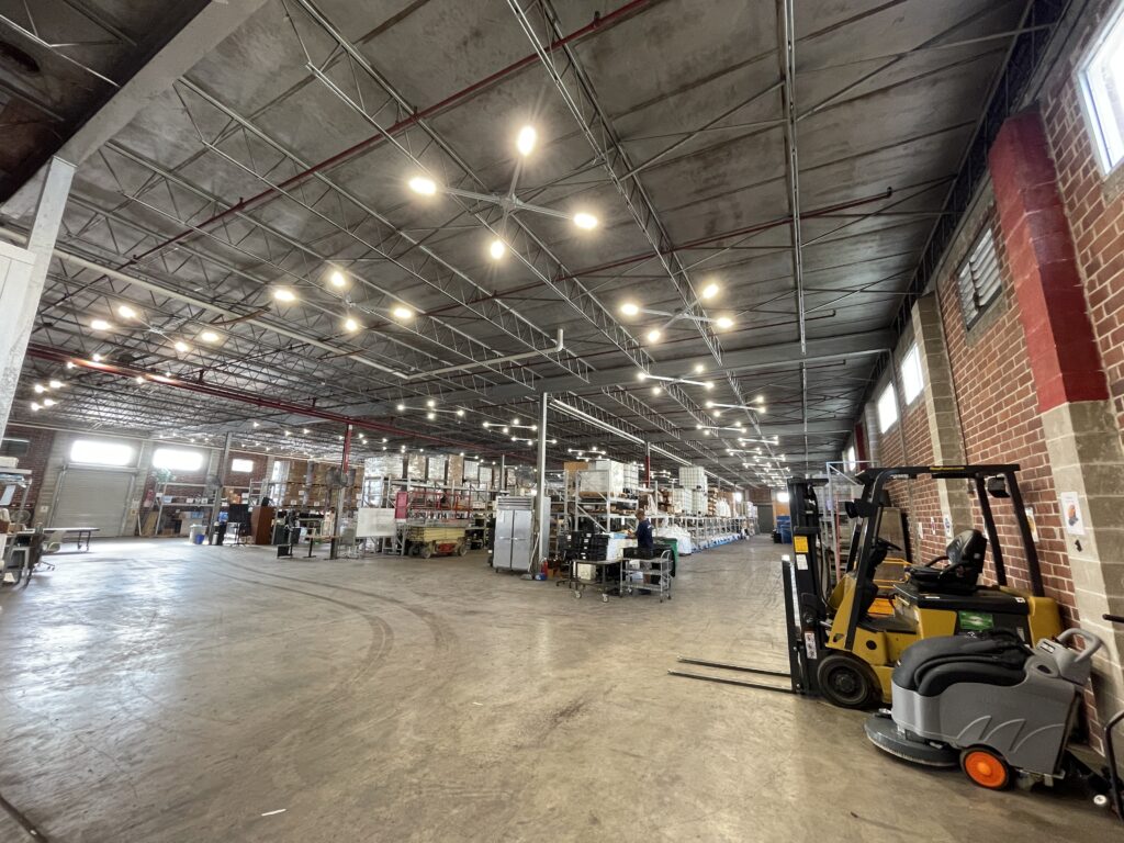 Warehouse floor with forklift under overhead lighting